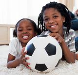 Little girl and her brother holding soccer ball