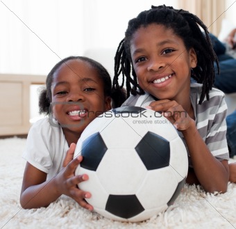 Little girl and her brother holding soccer ball