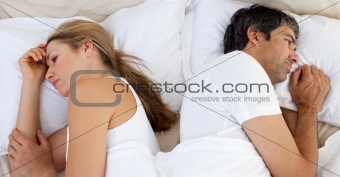 Upset couple sleeping separately