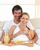 Close-up of couple having breakfast lying in the bed at home