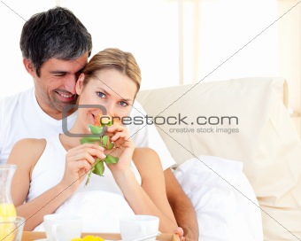 Close-up of couple having breakfast lying in the bed