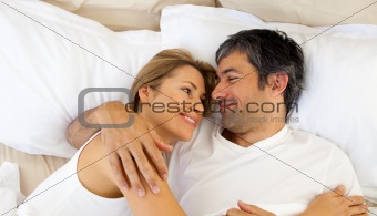  Affectionate couple hugging lying in bed