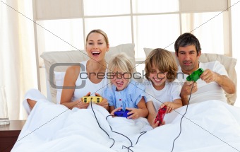 Loving family playing video game in the bedroom