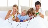 Adorable family playing video game in the bedroom