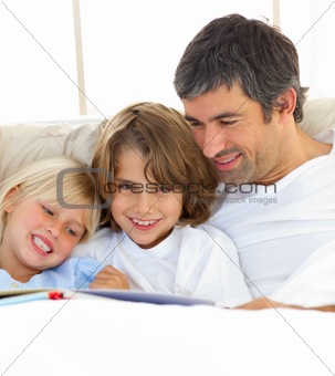 Close-up of father and his children reading book