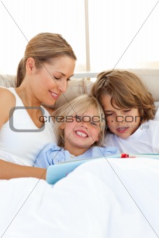 Pretty mother and her children reading book