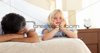 Little girl lying on bed with her father