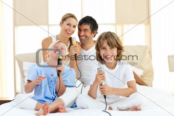 Portrait of a happy family sitting on a bed at home