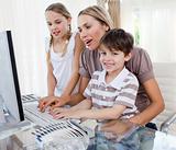 Happy mother and her children using a computer at home