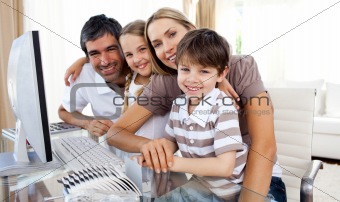 Portrait of a smiling family at a computer
