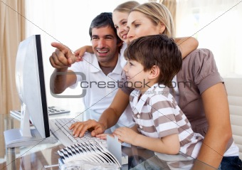 Children learning how to use a computer with their parents