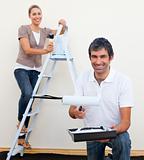 Happy man and woman decorating a room