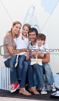 Portrait of a happy family decorating a room 