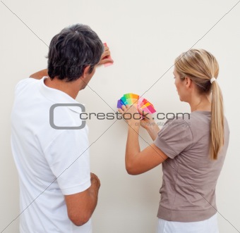 Couple choosing a color to paint a room 