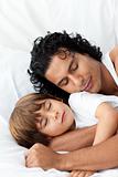 Little boy and his father sleeping together