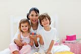 Attractive mother and her children playing with letters blocks