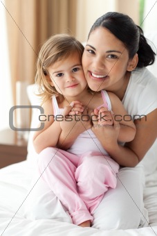 Smiling mother hugging her little girl 