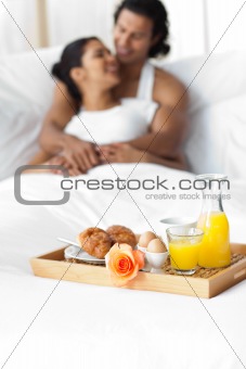 Smiling lovers having breakfast on the bed 