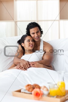 Lovers having breakfast lying on the bed 