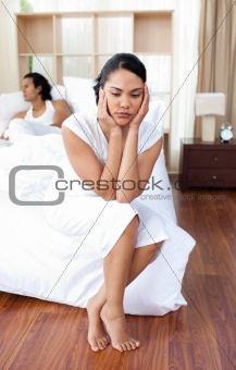 Young couple sitting on the bed separately 