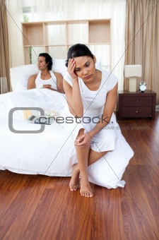 Young lovers sitting on the bed separately