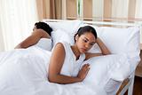Upset woman in bed sleeping separate of a man