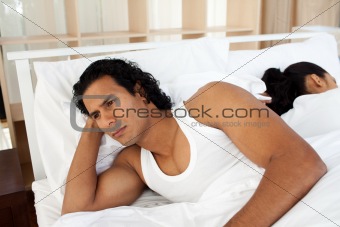 Upset man in bed sleeping separate of a woman