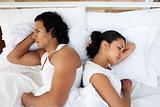 Upset couple lying in the bed after having an argument