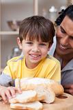 Smiling child eating bread with his father