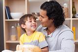 Cheerful child eating bread with his father
