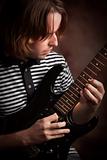 Young Musician Plays His Electric Guitar with Dramatic Lighting.