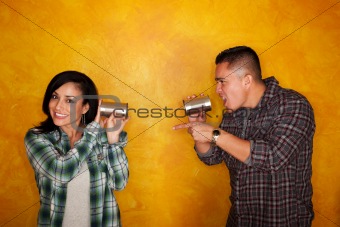Hispanic man and woman communicate through tin cans