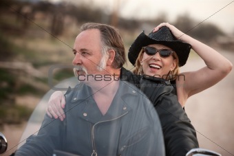 Mature couple riding a motorcycle in the desert