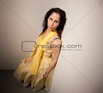 Serious looking woman in a yellow dress