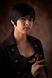 Pretty Multiethnic Young Adult Woman Holding a Single Rose Portrait with Selective Focus.
