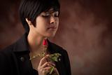 Pretty Multiethnic Young Adult Woman Holding a Single Rose Portrait with Selective Focus.