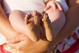 Baby feet covered in beach sand
