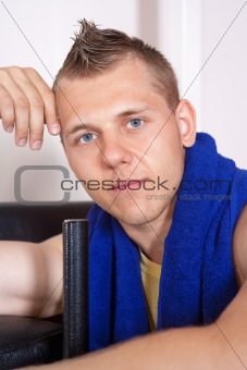 portrait of a young man with towel in modern gym
