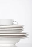 studio shot of a pile of white plate and white cup isolated on white