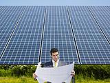 businessman standing near solar panels