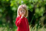 boy with long blond hair and grass straw in the garden