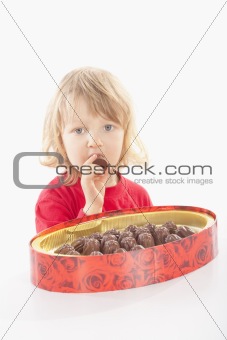 boy with long blond hair and a box of chocolate - isolated on white