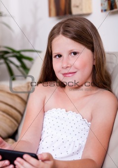 Young smiling girl looking at you in living room