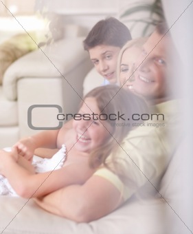 Happy family smiling and looking  behind the window glass 
