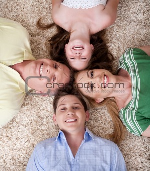 Happy family lying with their heads close together smiling 