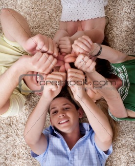 Happy family lying  and showing thumps up together