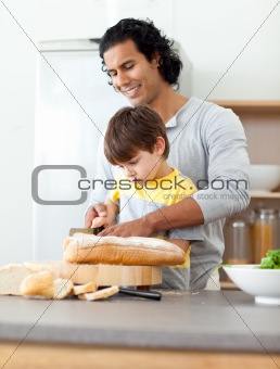 Charming father cutting bread with his son