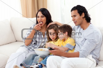 Lively family watching TV on sofa