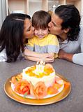 Cute child celebrating his birthday with his parents