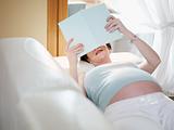 pregnant woman reading book at home